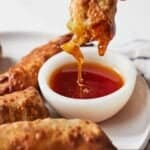 Pinterest graphic of half an air fryer egg roll dipped into sauce.