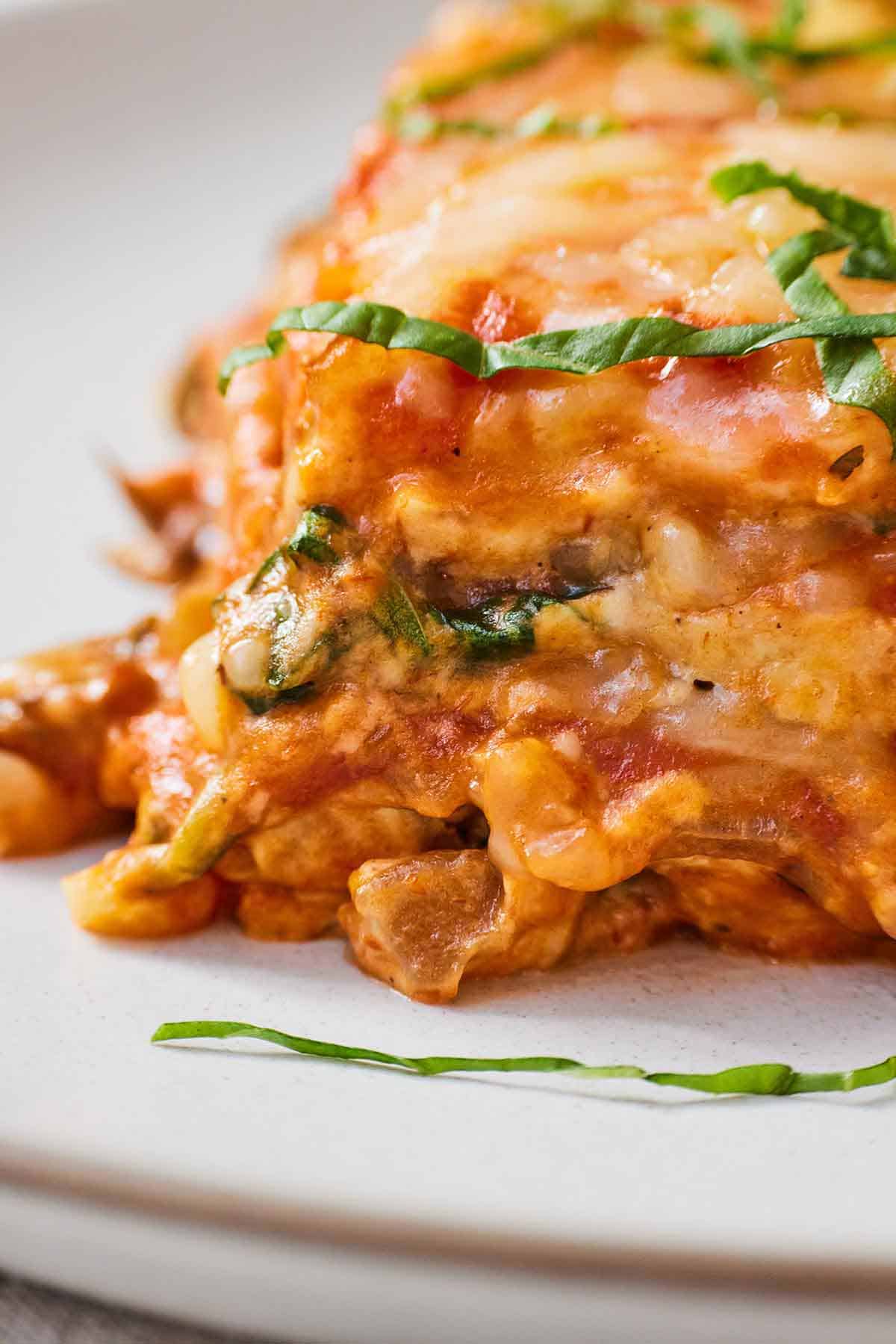 Close up of vegan lasagna with basil garnish.