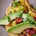 Pinterest graphic of a close up view of sliced avocados in a breakfast taco.