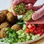 Pinterest graphic of a falafel torn in half by a hand.