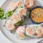 Pinterest graphic of a plate of three salad rolls with a bowl of peanut sauce on the side.