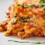 Pinterest graphic of a close up view of vegan lasagna on a plate.