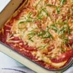 Pinterest graphic of a baking dish of vegan lasagna with ribboned basils on top.