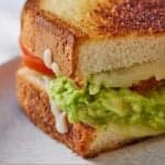 Pinterest graphic of a close view of a cut avocado grilled cheese, showing the filling.