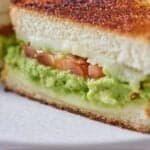 Pinterest graphic of an avocado grilled cheese, showing the cheese, avocado, and tomatoes.