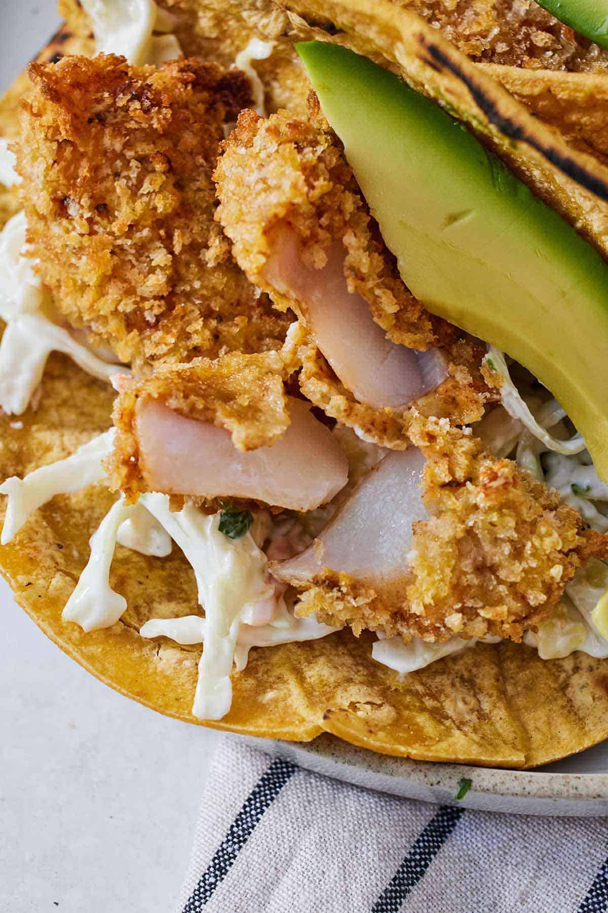 Close view of crispy fish torn open in an air fryer fish taco.