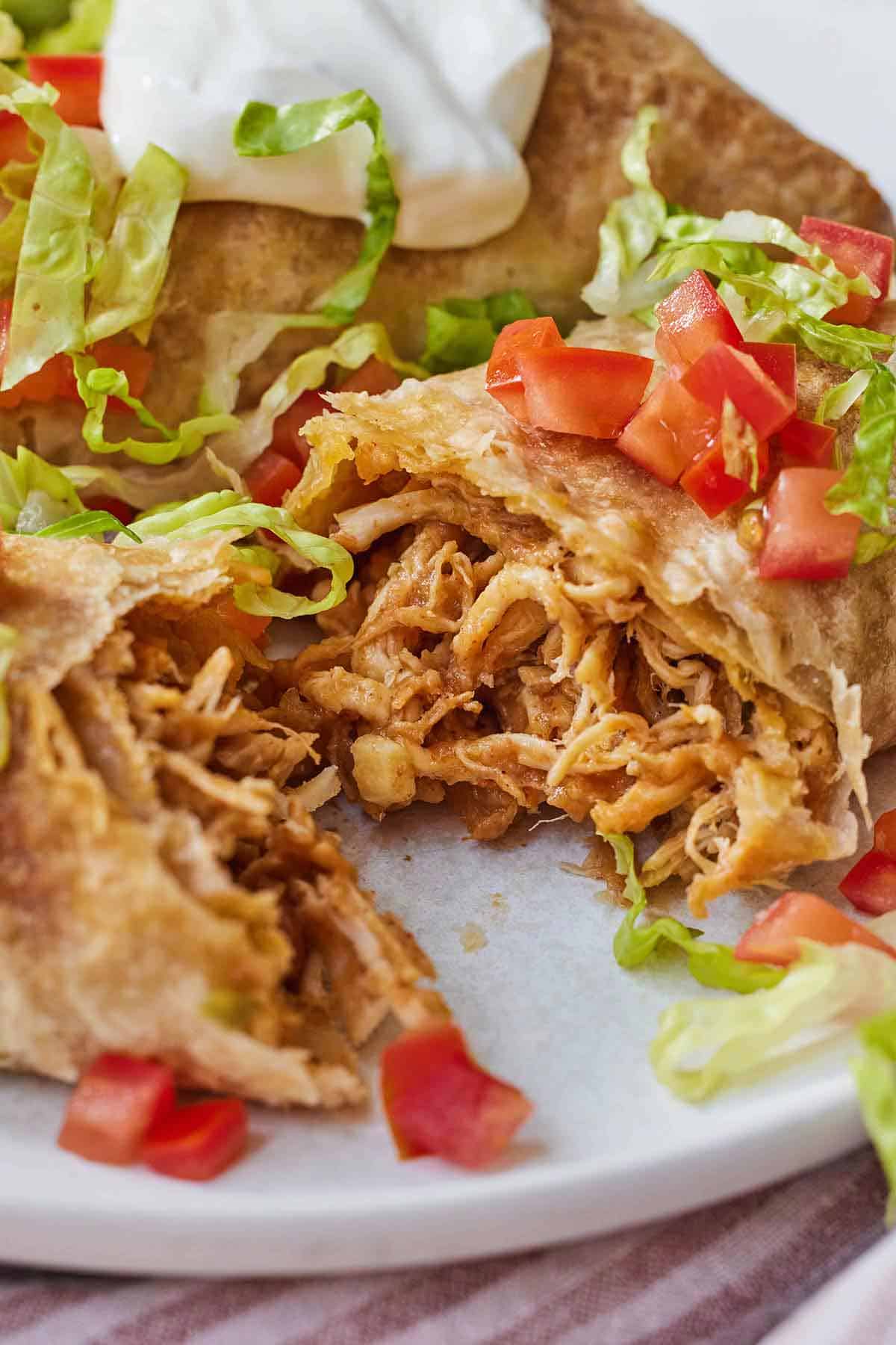 A chicken chimichanga cut in half, showing the shredded chicken inside.