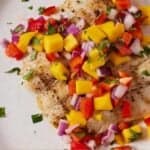 Pinterest graphic of a plate of grilled halibut with freshly made mango salsa on top.