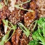 Pinterest graphic of a close up view of orange beef with green onions and sesame seeds on top with some broccoli and rice.