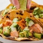 Pinterest graphic of a lime wedge squeezed onto a salmon taco.