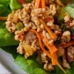 Pinterest graphic of a close up view of the filling of a Thai chicken lettuce wrap.