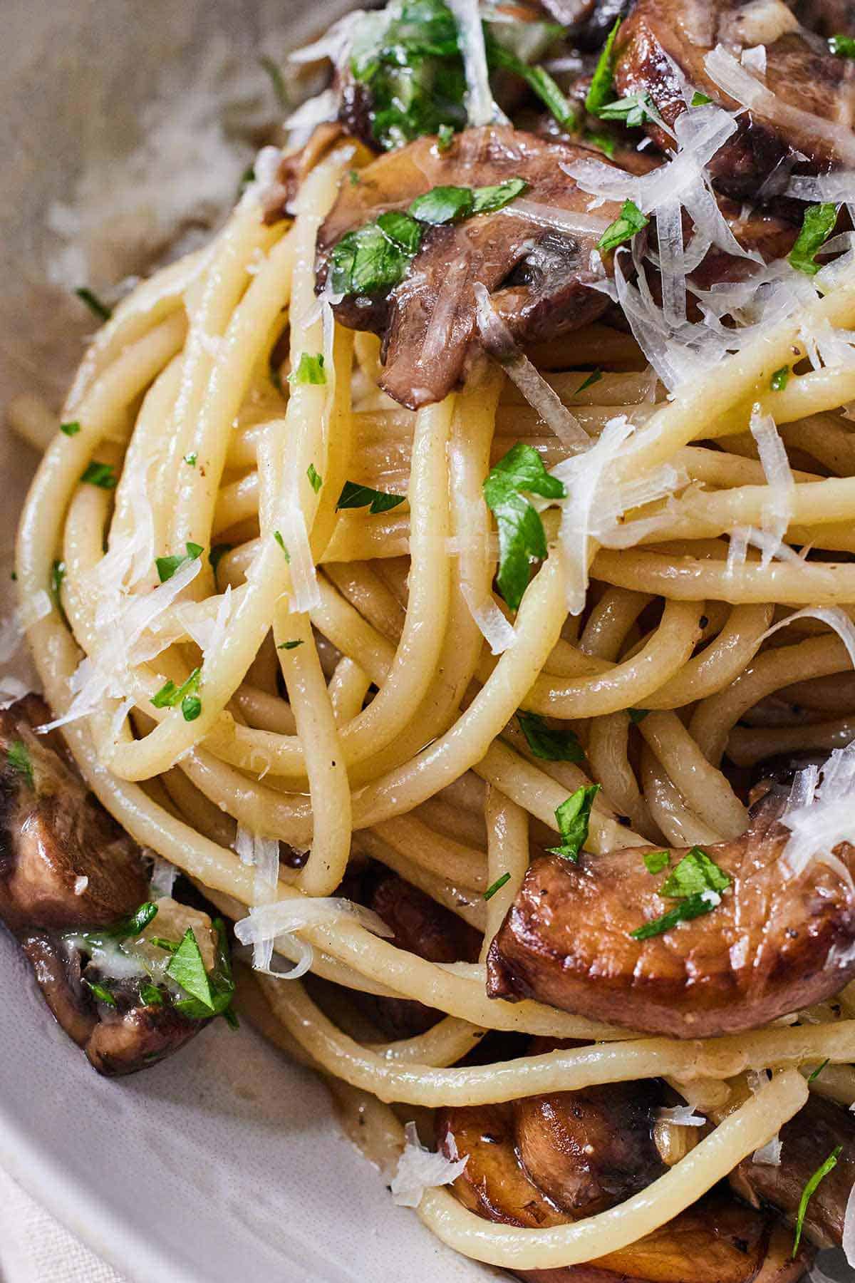 Close up of garlic mushroom pasta with freshly grated parmesan and parsley.