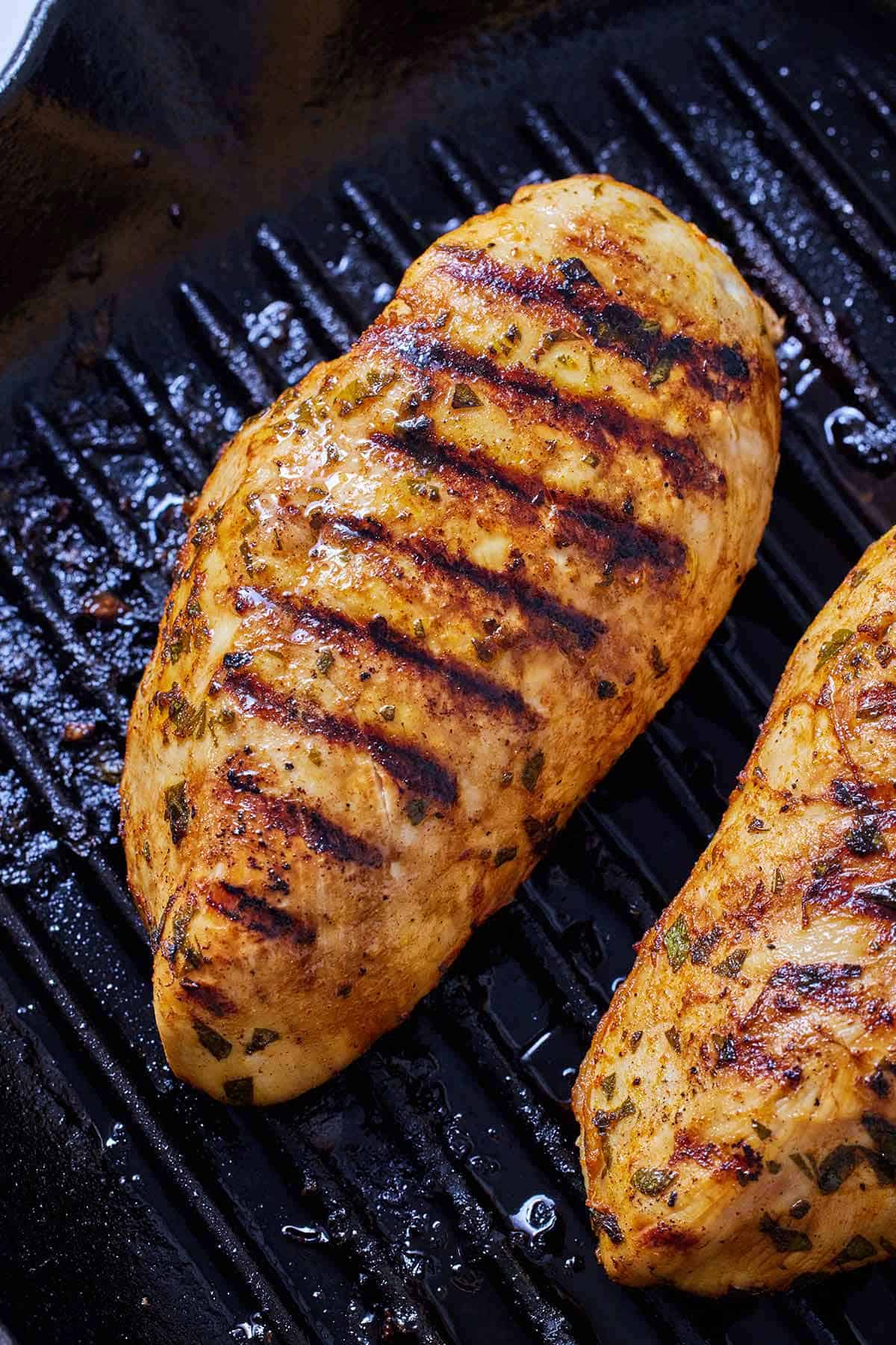 Overhead view of Mediterranean grilled chicken on a grill pan.