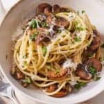 Pinterest graphic of a bowl of garlic mushroom pasta with parmesan and parsley on top.