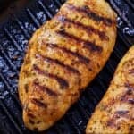 Pinterest graphic of a grilled Mediterranean chicken breast on a grill pan.