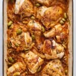 Pinterest graphic of a white baking dish with saucy braised chicken with sliced onions and olives tucked around each piece of chicken.