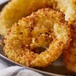 Pinterest graphic of a close up view of a golden air fryer onion ring.