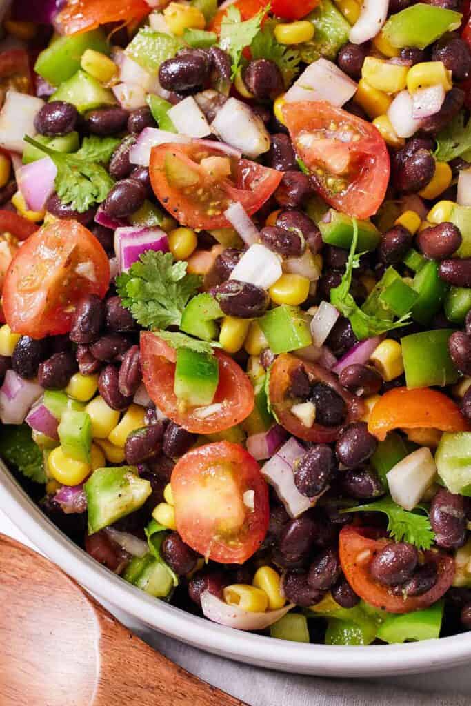 Close up of a bowl of black bean salad with fresh cilantro on top.