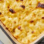 Pinterest graphic of a close view of baked cauliflower mac and cheese in a baking dish.