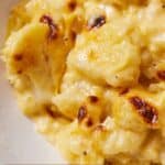 Pinterest graphic of a close up view of cauliflower mac and cheese in a bowl.