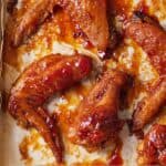 Pinterest graphic of a lined sheet pan with honey BBQ wings.