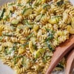 Pinterest graphic of a plate of summer squash pasta with two large wooden spoons on the side.