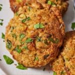 Pinterest graphic of a close up of an air fryer crab cake with two more by it.