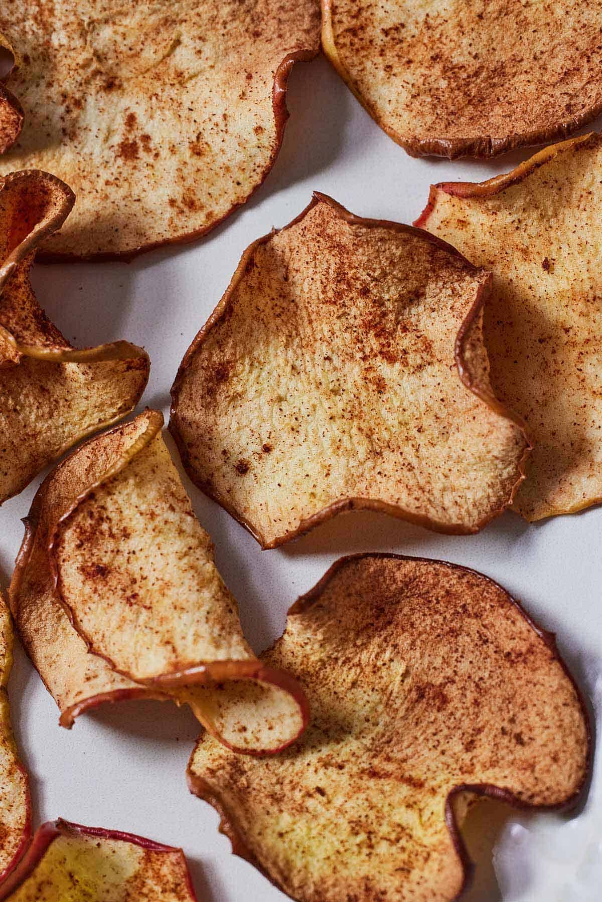 Close up view of air fryer apple chips with some folded.