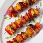 Pinterest graphic of an overhead view of three Hawaiian chicken skewers.