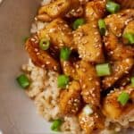 Pinterest graphic of honey garlic chicken bites with rice and green onions.
