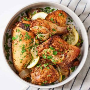 Overhead view of a large bowl of air fryer Lebanese chicken with fresh chopped parsley.