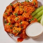 Pinterest graphic of a plate of air fryer cauliflower wings with celery and dipping sauce in a bowl.