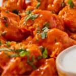 Pinterest graphic of a close up view of air fryer cauliflower wings with chopped fresh herbs on top.
