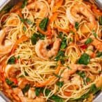 Pinterest graphic of an overhead view of a skillet of red curry pasta with shrimp.