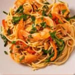 Pinterest graphic of a plate of red curry pasta with shrimp.