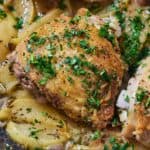 Pinterest graphic of a close up view of a piece of apple cider chicken with chopped parsley on top.