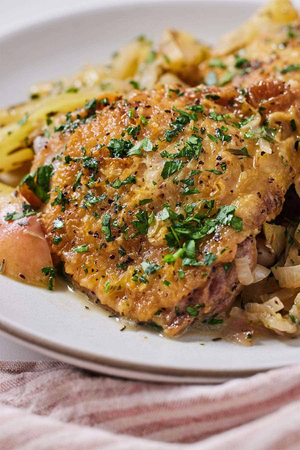 Close up of apple cider chicken with chopped parsley on top.