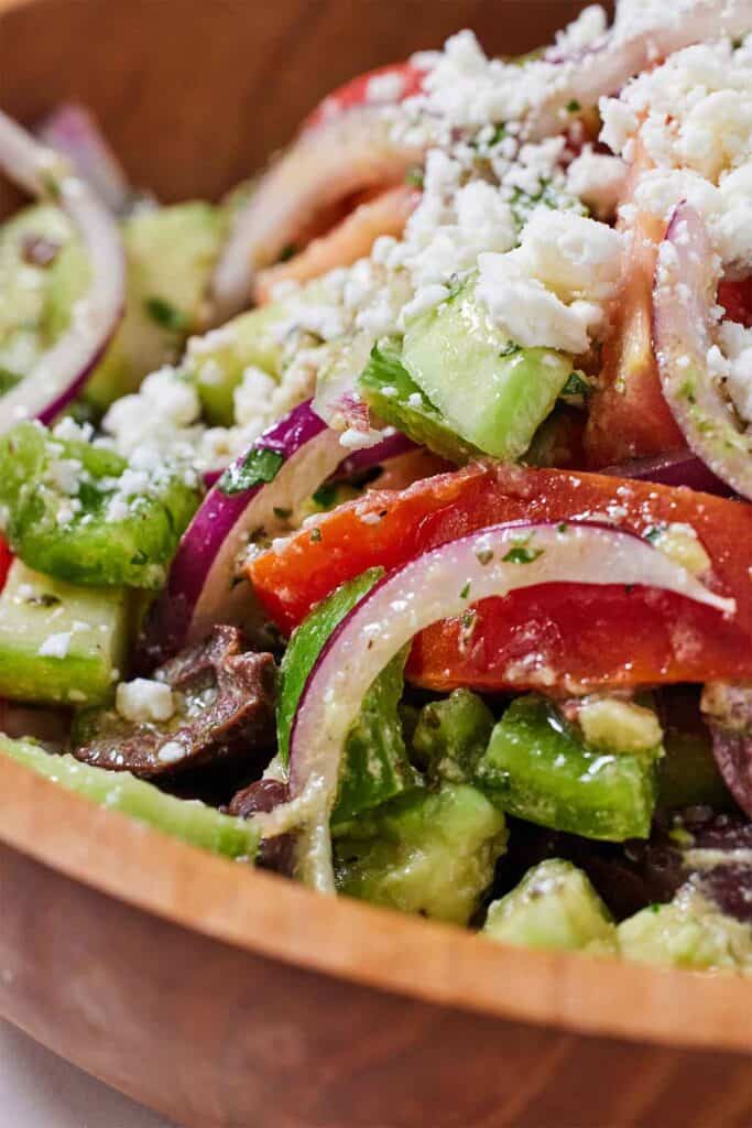 Close up view of the red onions, avocado, tomatoes of a avocado Greek salad.cucumbers, and