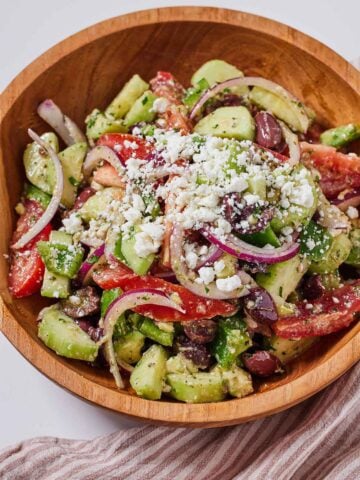 A bowl of avocado Greek salad with crumbled feta on top.
